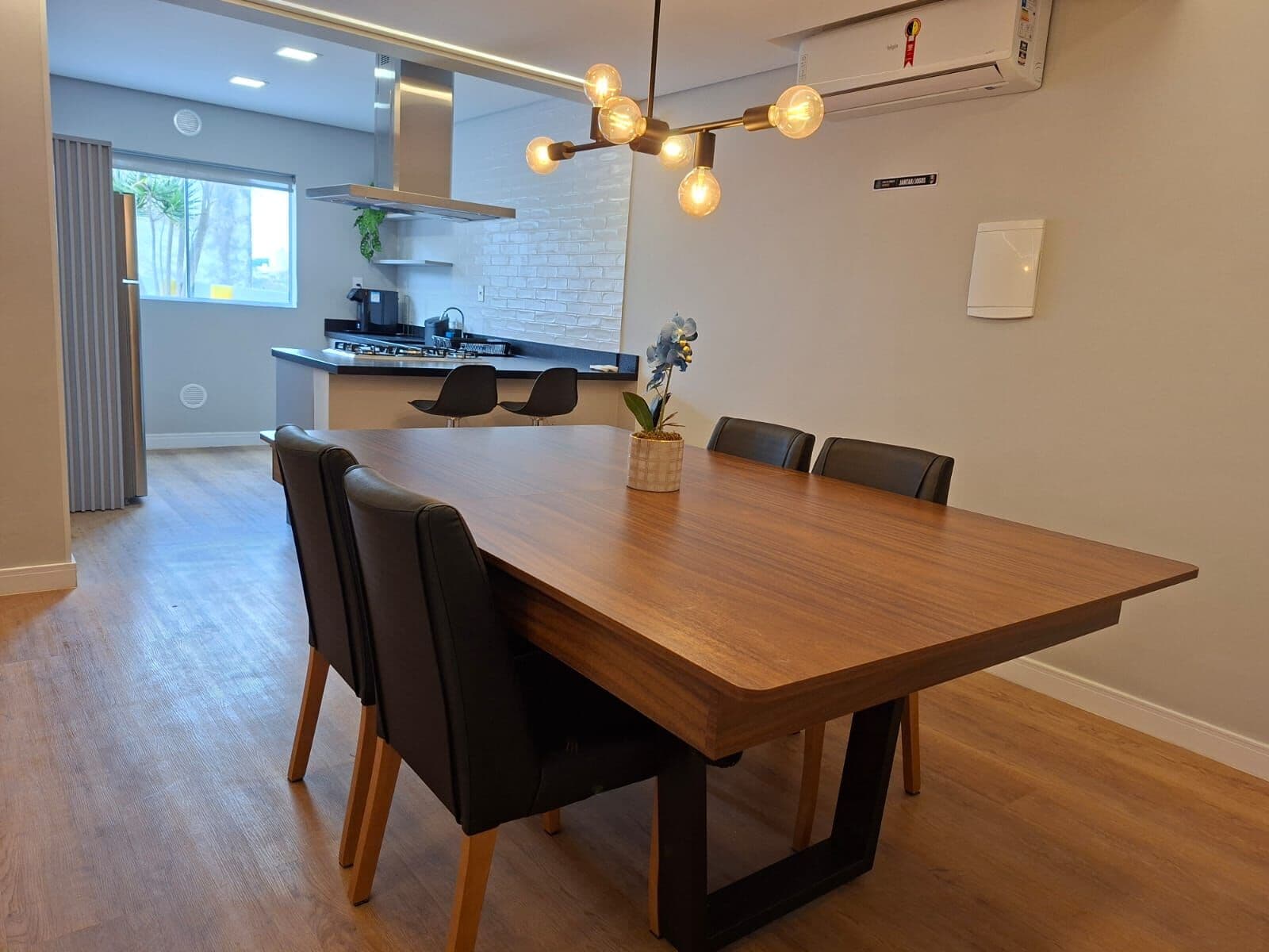 Mesa de jantar grande com a cozinha ao fundo
