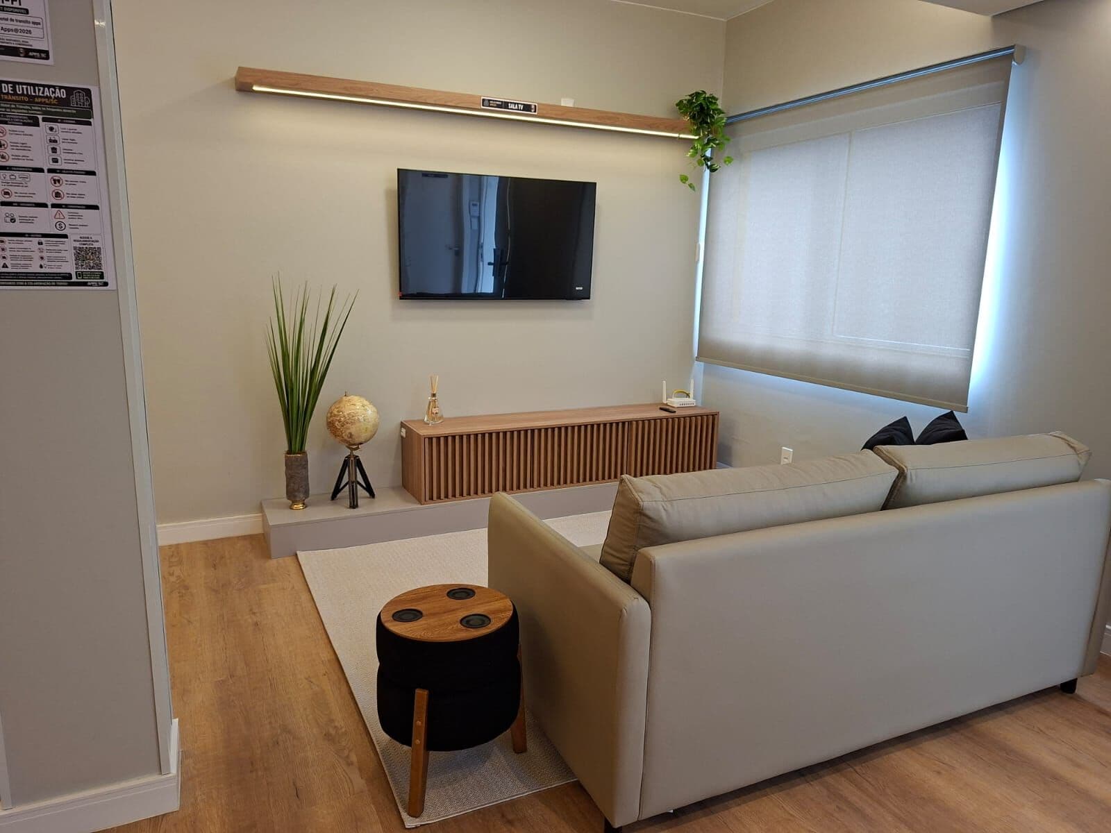 Sala de TV com sofá e televisão na parede