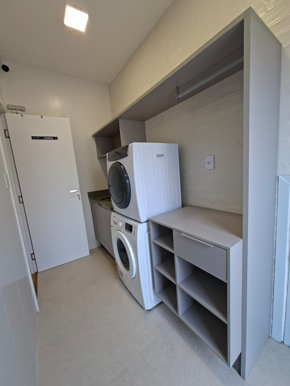 Área de serviço com lavadora, secadora e armários